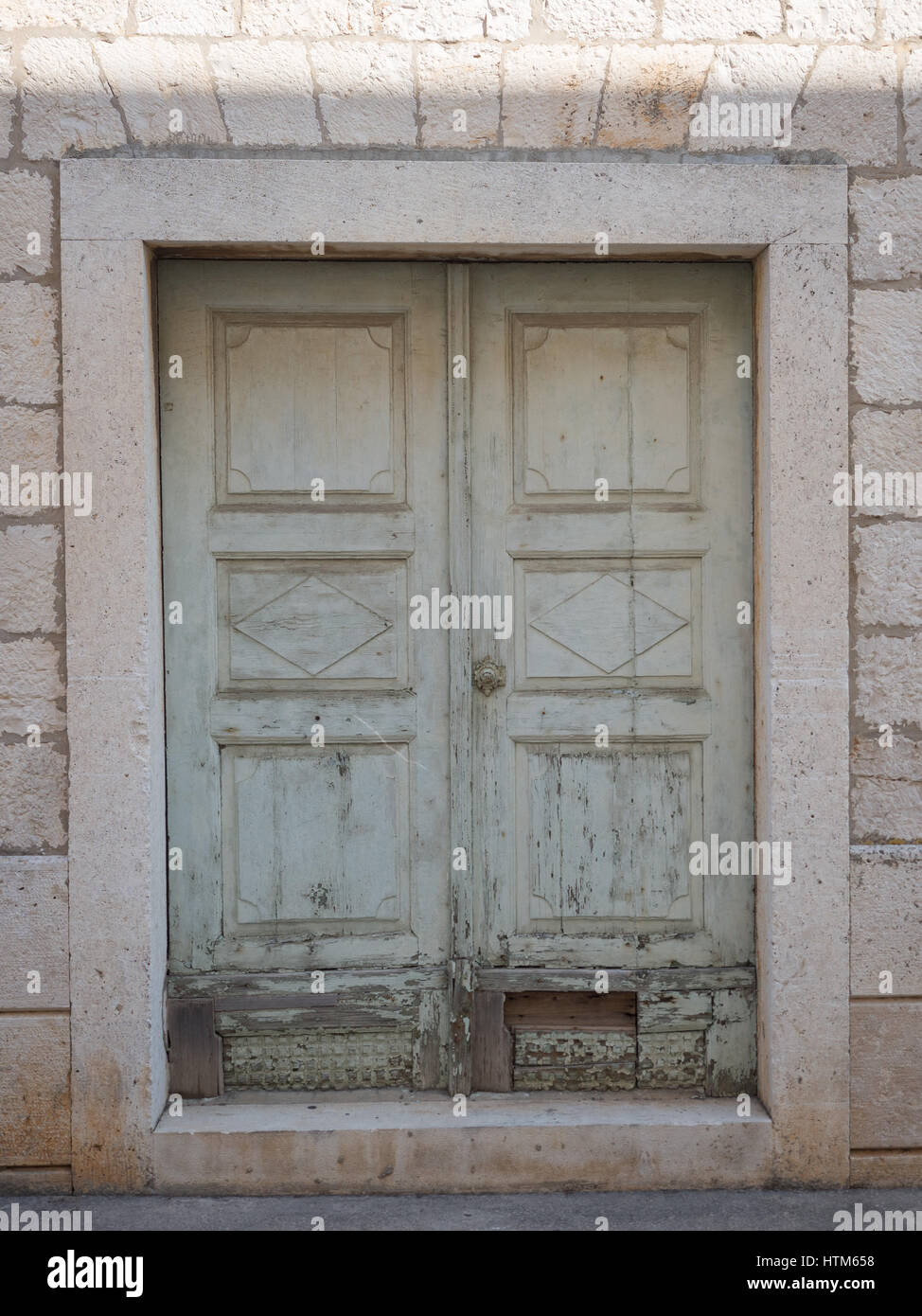 Un vieux antique a endommagé la peinture verte de déroulage porte peinte dans le cadre dans mur de pierre Croatie Banque D'Images