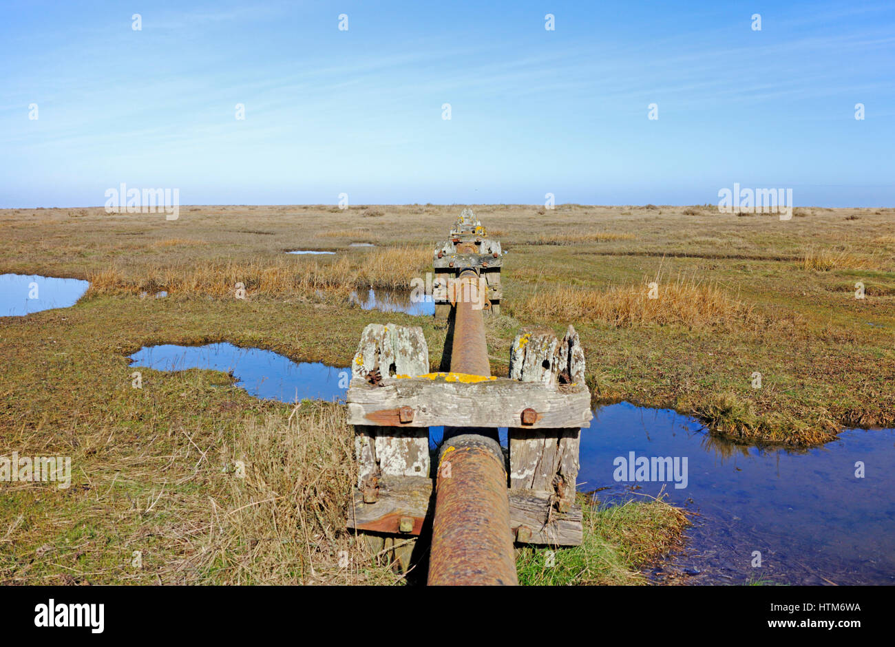 Une vue sur les marais de sel avec tuyau d'égout désaffecté sur la côte nord du comté de Norfolk à Stiffkey, Norfolk, Angleterre, Royaume-Uni. Banque D'Images