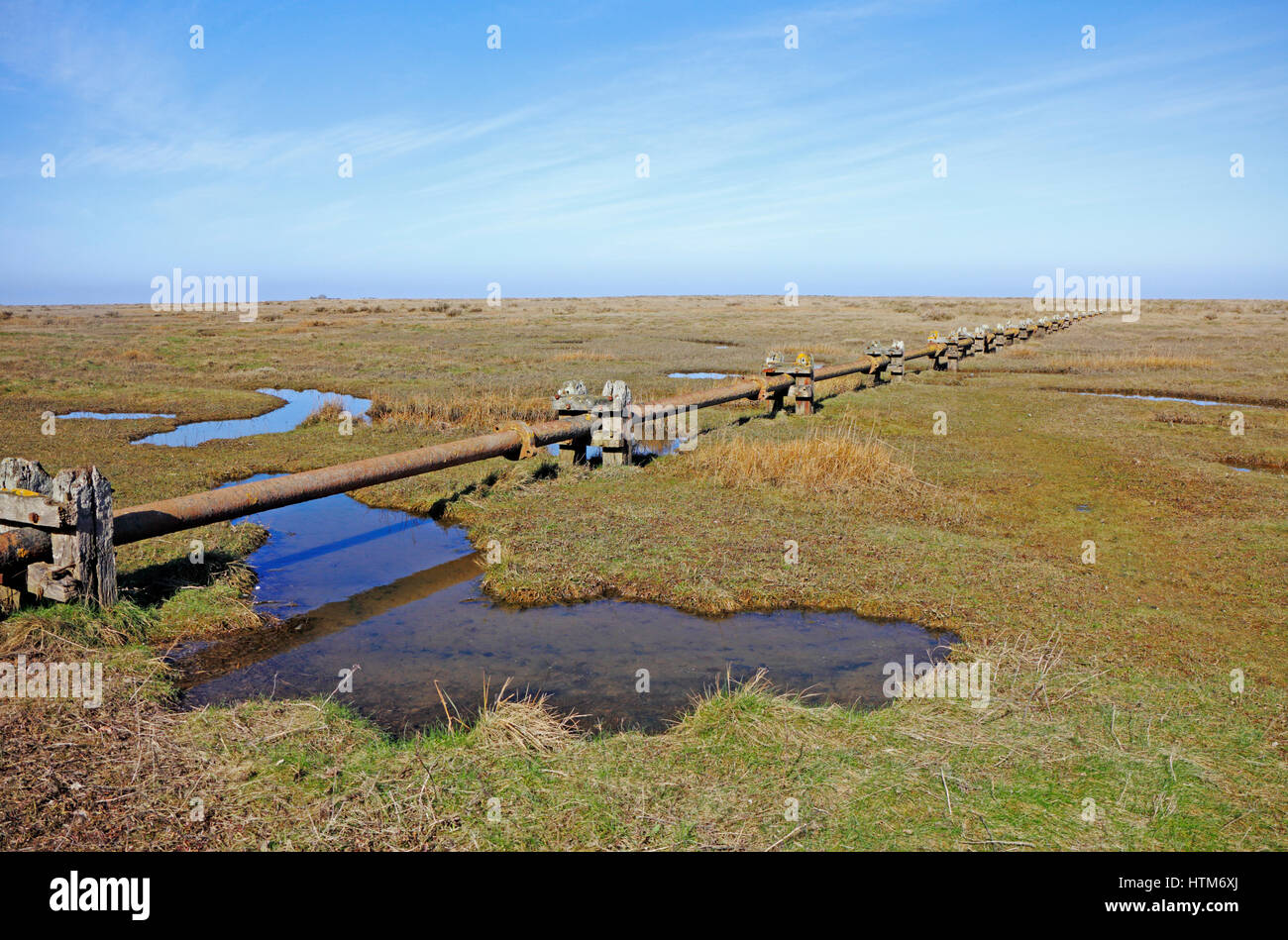 Une vue sur les marais de sel avec tuyau d'égout désaffecté sur la côte nord du comté de Norfolk à Stiffkey, Norfolk, Angleterre, Royaume-Uni. Banque D'Images
