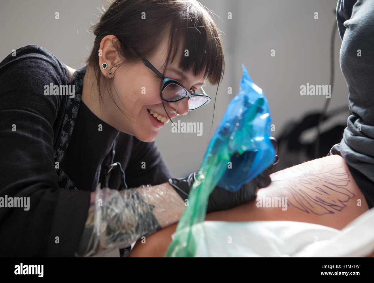 Jeune fille maître tatouage au travail Banque D'Images