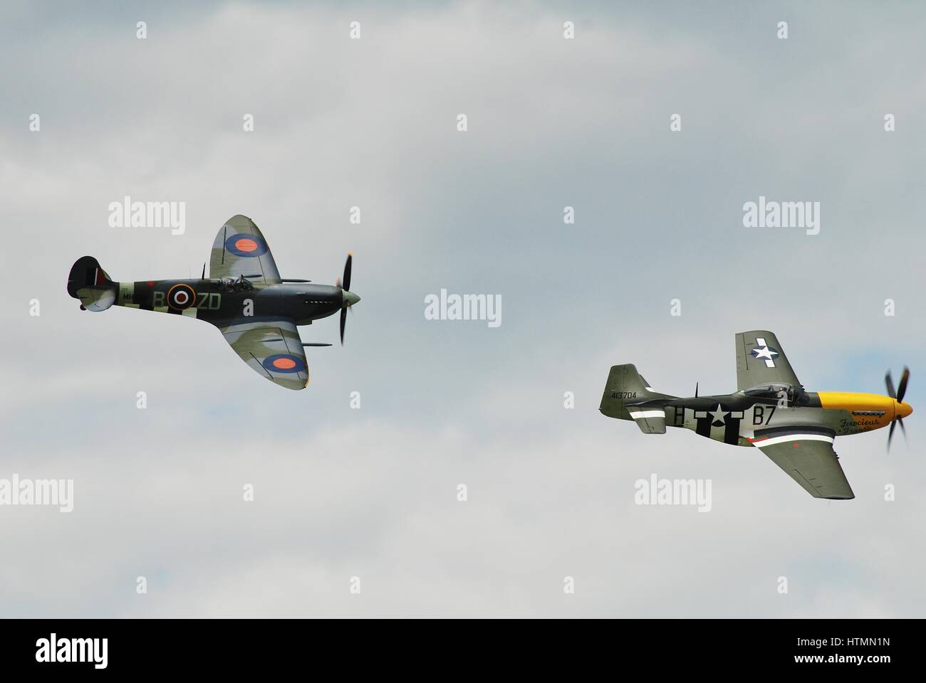 Mustang P51D féroce chasse Frankie mène Vickers chasseur Spitfire MH434 au Dunsfold airshow à Surrey, en Angleterre. Les deux avions datent de la SECONDE GUERRE MONDIALE. Banque D'Images