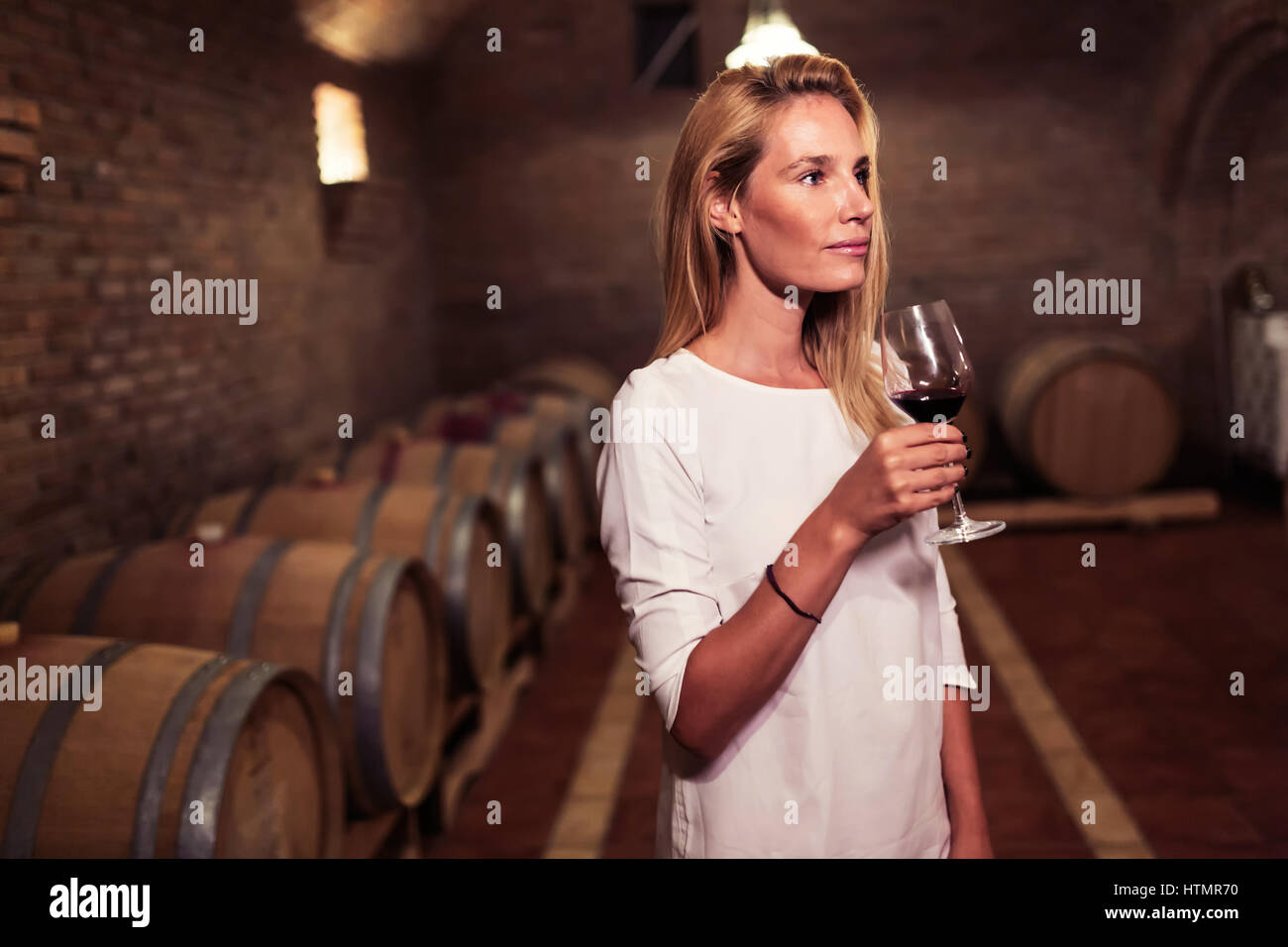 Belle femme oenologue vin dégustation dans cave vigneron Banque D'Images