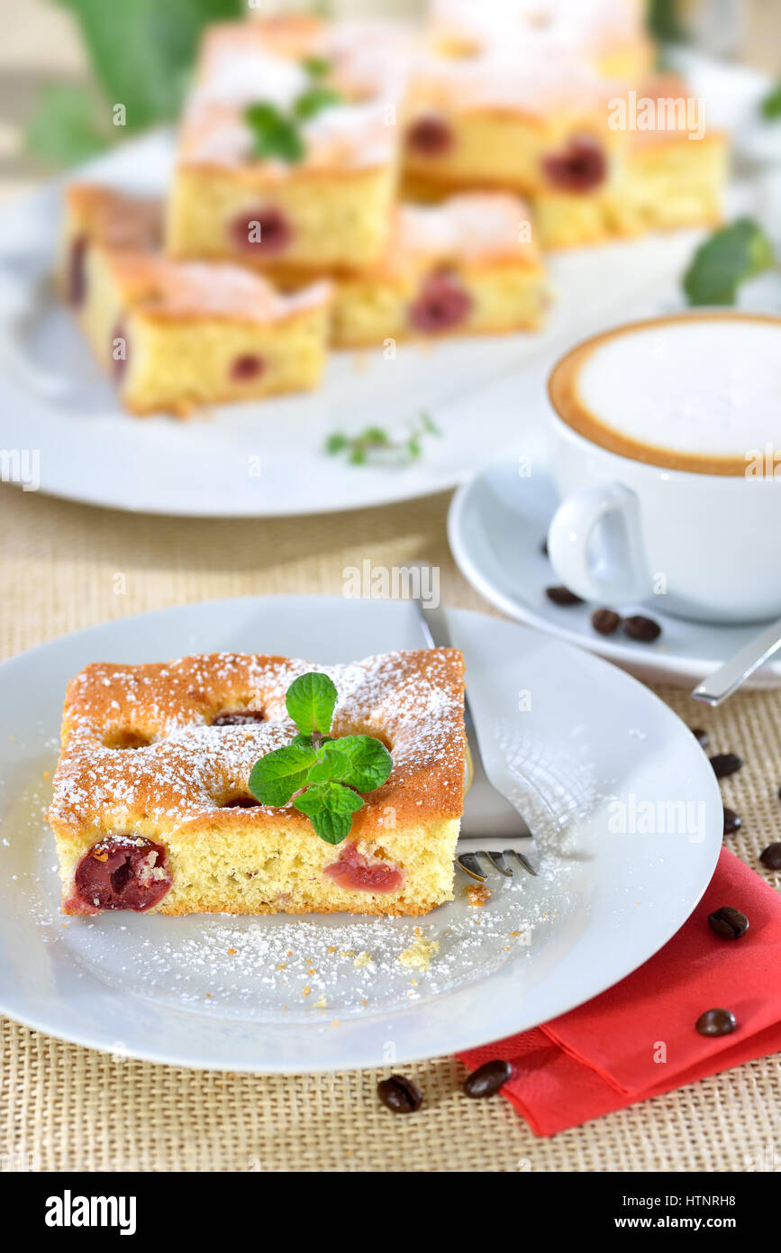 Délicieux morceau de gâteau cerise avec une tasse de cappuccino Banque D'Images