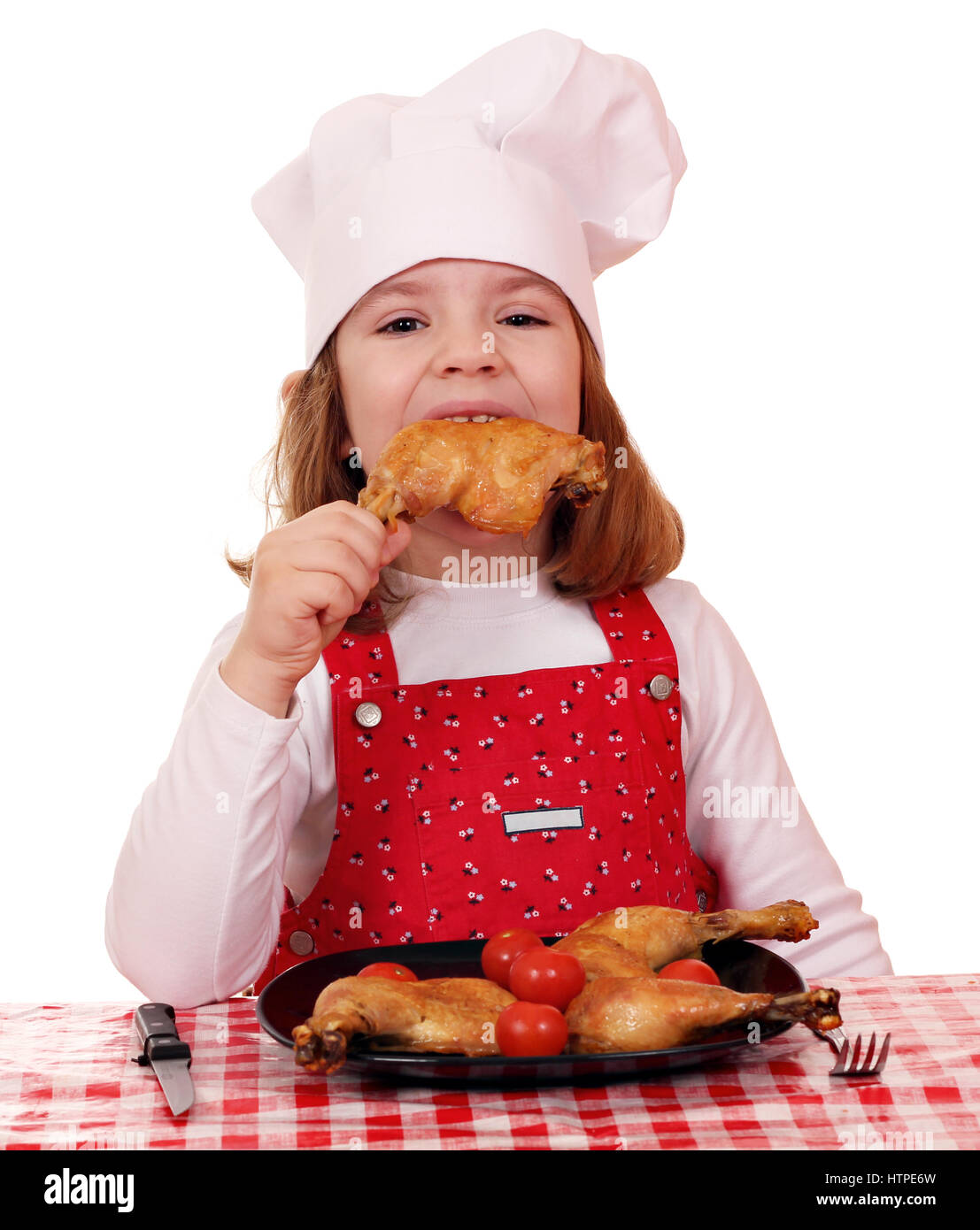 Petite fille faim manger cook pilons de poulet Banque D'Images