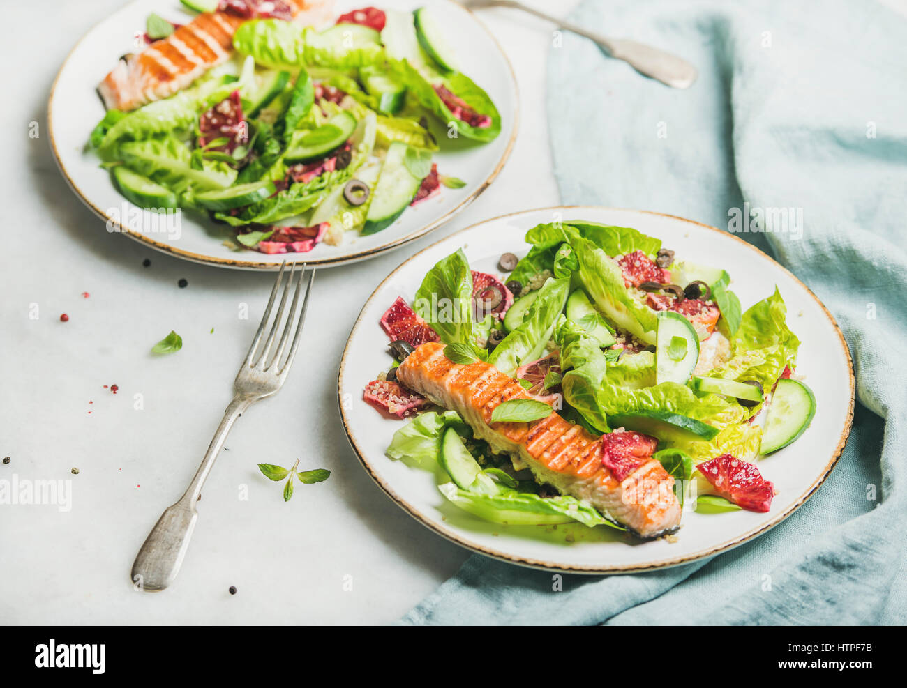 L'énergie saine stimuler salade de printemps avec du saumon grillé, d'orange sanguine, olives, concombre et le quinoa, selective focus, en arrière-plan. L'alimentation, Banque D'Images