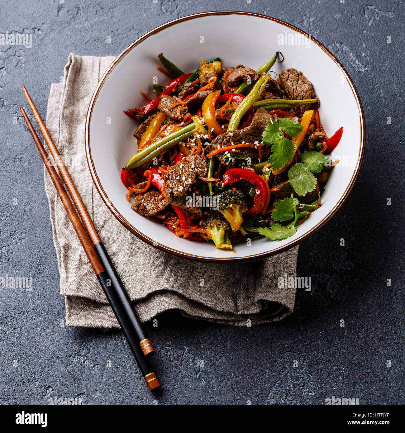 Sauté de boeuf du Sichuan avec des légumes dans un bol de pierre sombre contexte Banque D'Images