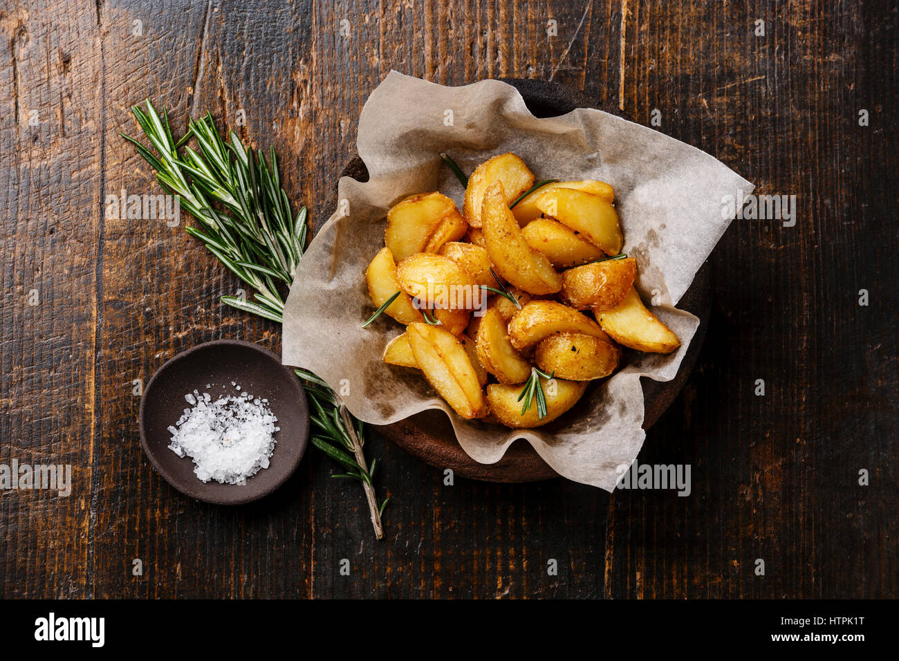 Pays frit-style les quartiers de pommes de terre et de sel sur fond de bois Banque D'Images