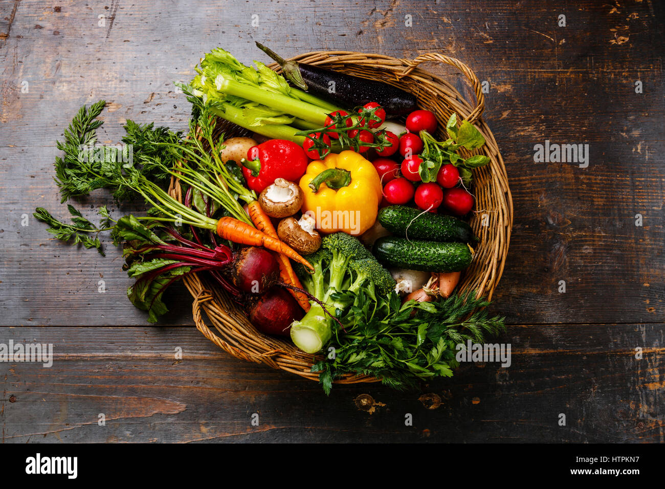 Des légumes frais dans le panier sur fond de bois Banque D'Images
