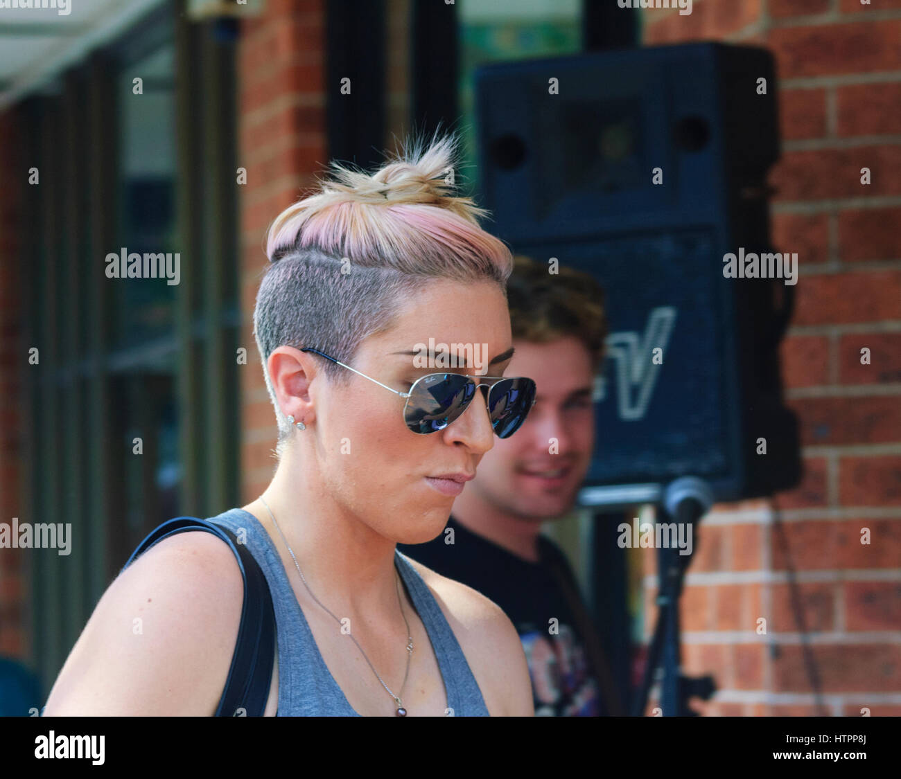 Le punk-à la femelle avec la tête rasée partiellement et lunettes à Kiama Jazz & Blues Festival 2017, Côte d'Illawarra, New South Wales, NSW, Australie Banque D'Images