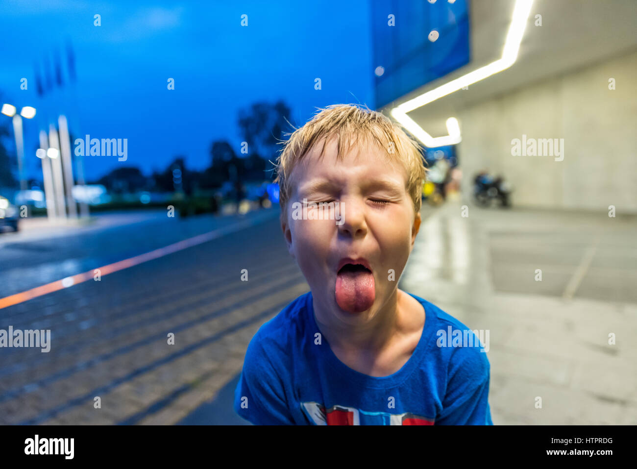 Petit garçon montrant sa langue avec expression aponévrotique. Banque D'Images