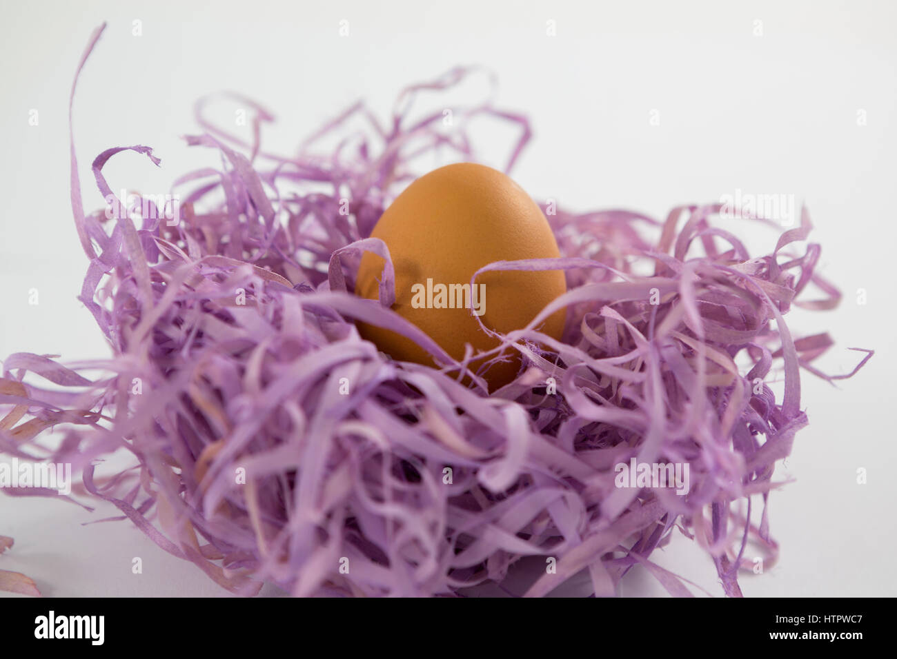 Close-up of brun oeufs de Pâques dans le nid de papier sur fond blanc Banque D'Images