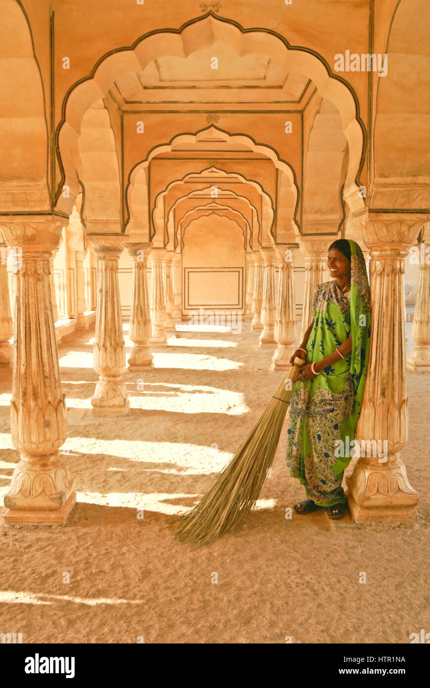 Travailleur avec un balai dans le hall de l'auditoire à l'Amer (Orange) Fort, Jaipur, Rajasthan, Inde Banque D'Images