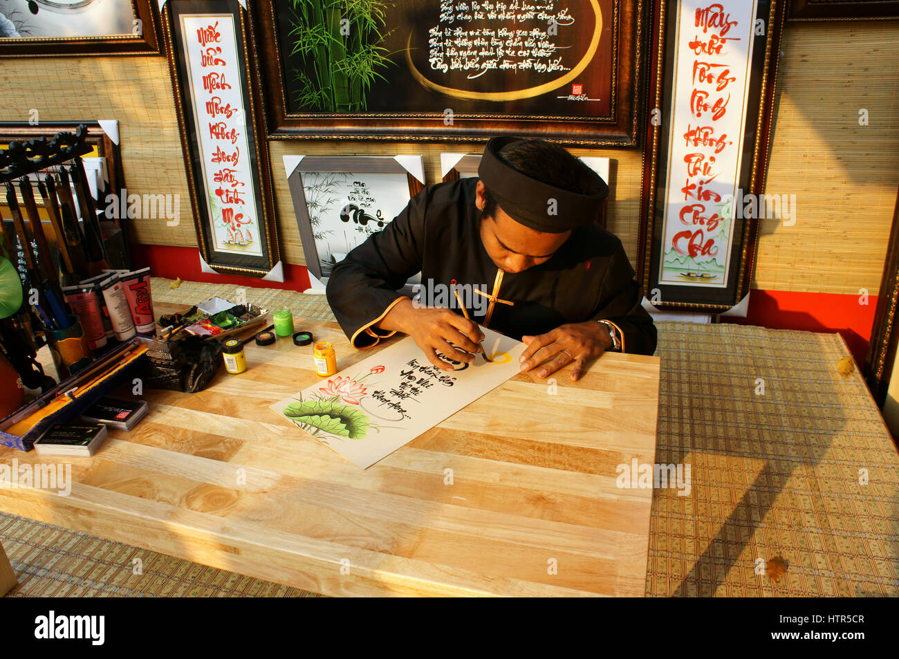 HO CHI MINH ville, VIET NAM, l'atmosphère de printemps en scène colorée, l'homme vietnamiens en ao dai, écrire l'écriture chinoise, la calligraphie Tet juste, Vietnam Banque D'Images