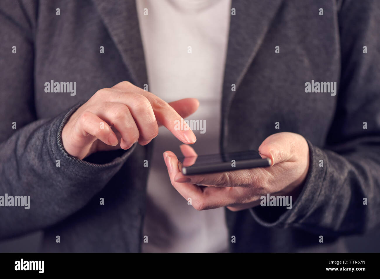 L'envoi de message SMS à l'aide femme téléphone mobile avec écran tactile, selective focus Banque D'Images