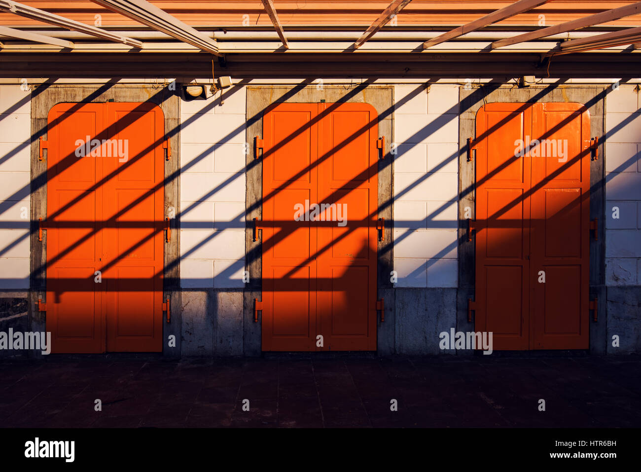 Résumé Contexte L'architecture, trois portes orange et les ombres, les formes et les lignes de la composition Banque D'Images