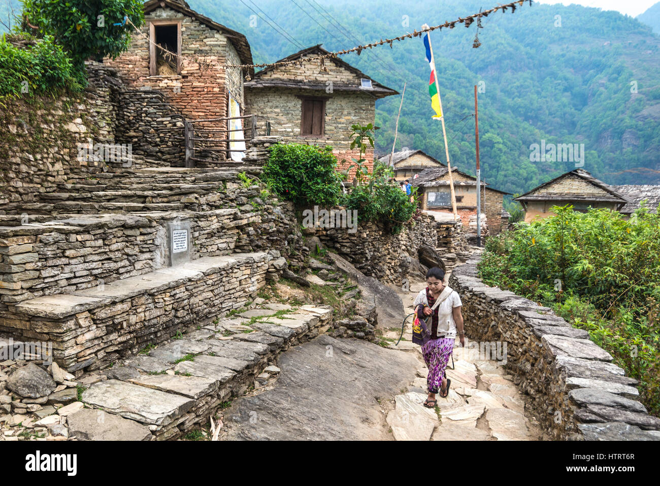 Une femme marche dans une ruelle à l'Sidhane rural village sur les pentes de la montagne, le Népal. Panchase Banque D'Images