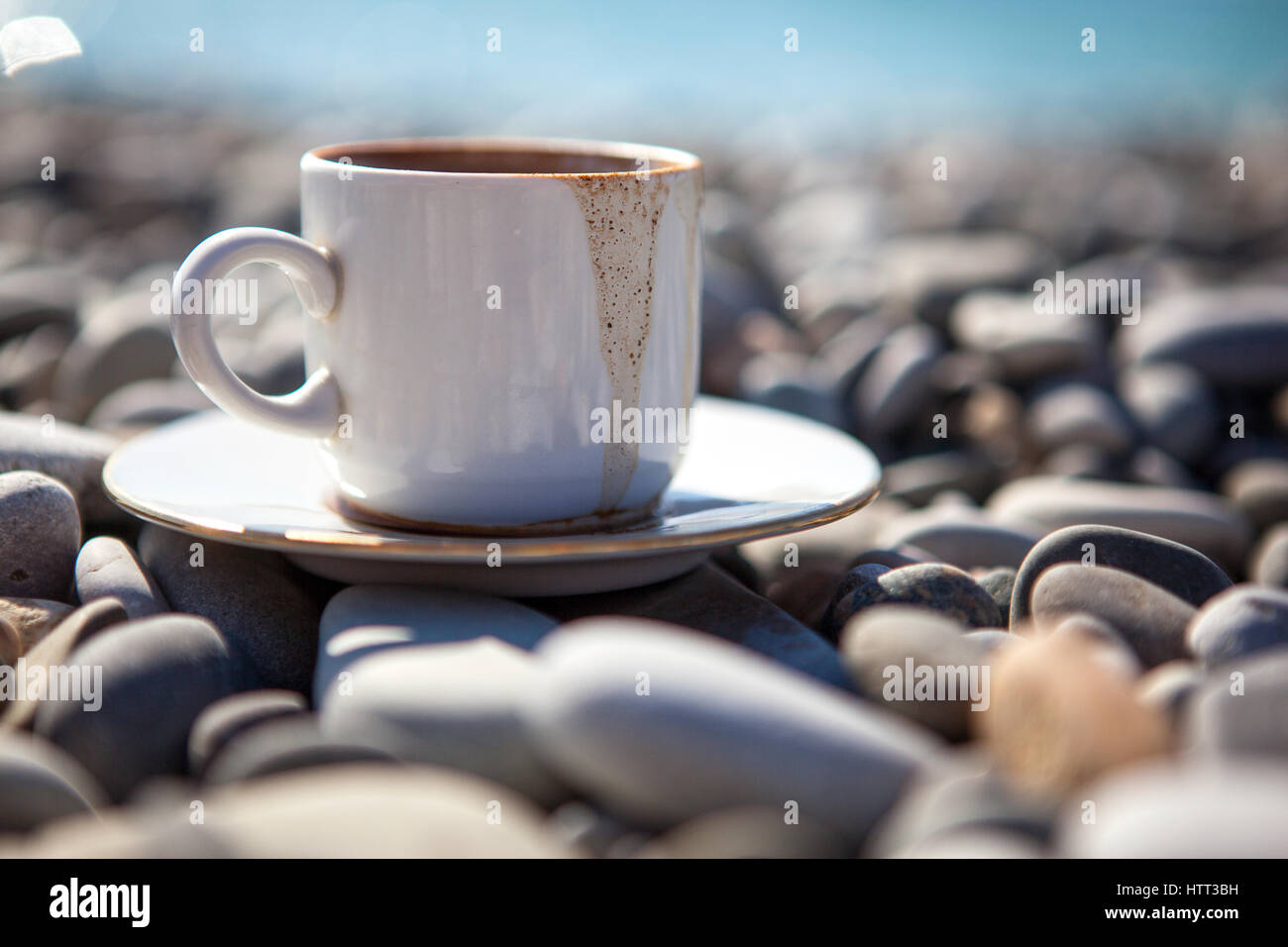Une tasse de café renversé se dresse sur des pierres près de la rive de la mer, Close up. Banque D'Images Une tasse de café renversé se dresse sur des pierres près de la rive de la mer, Close up. Banque D'Images