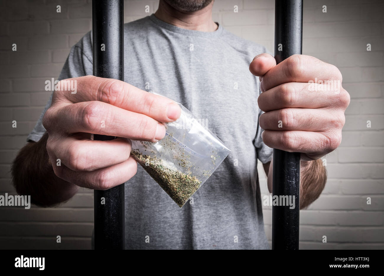 Un prisonnier derrière les barreaux de prison holding drogues ou psychotropes légales Spice (photo posée par modèle pour illustrer le problème des drogues dans les prisons du Royaume-Uni) Banque D'Images