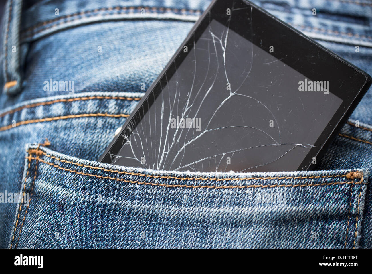 Broken smartphone dans la poche arrière des jeans Banque D'Images