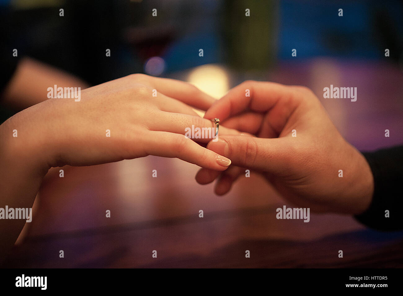 Jeune homme fait femme proposition de mariage et met une bague de  fiançailles à son doigt. Close up. Ils sont assis à table Photo Stock -  Alamy