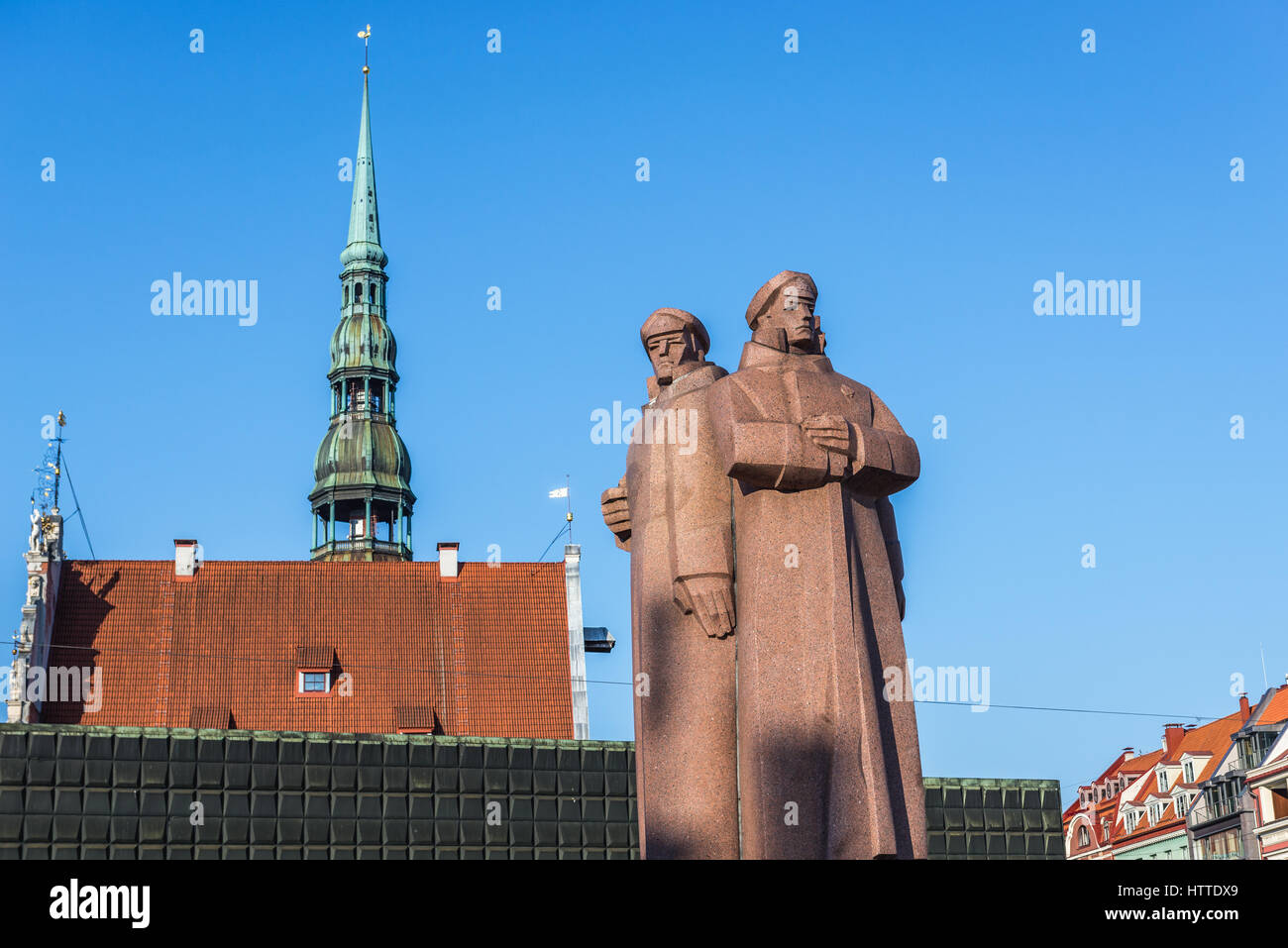 Monument des tirailleurs lettons sur la vieille ville de Riga, capitale de la République de Lettonie. Tour de l'église Saint Pierre sur l'arrière-plan Banque D'Images