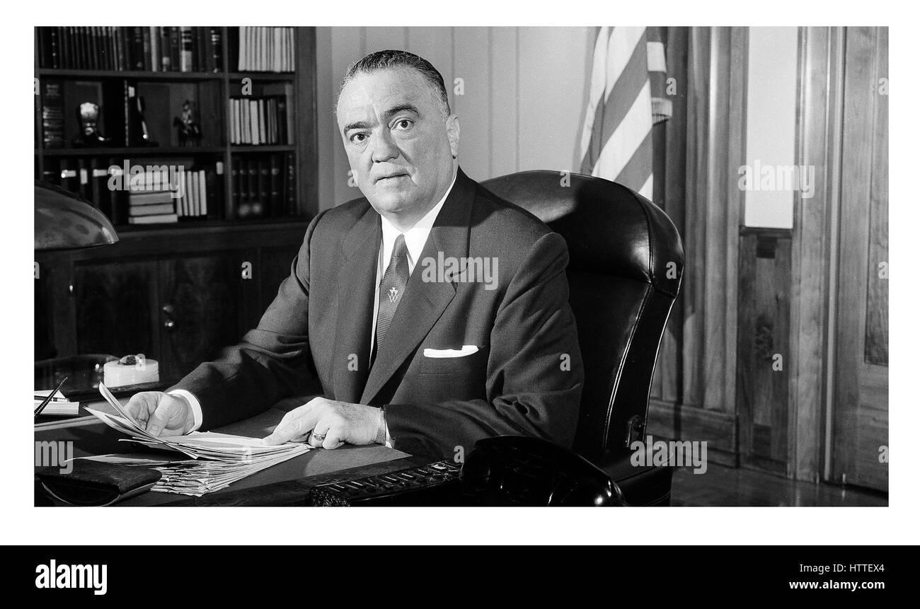 J Edgar Hoover, portrait, directeur du FBI dans les années 1960 à son bureau avec le drapeau américain derrière USA Amérique les États-Unis d'Amérique. Le bureau J. Edgar Hoover est un immeuble de bureaux de faible hauteur situé au 935 Pennsylvania Avenue NW à Washington, D.C. aux États-Unis. Il est toujours le siège du Federal Bureau of investigation (FBI). Banque D'Images
