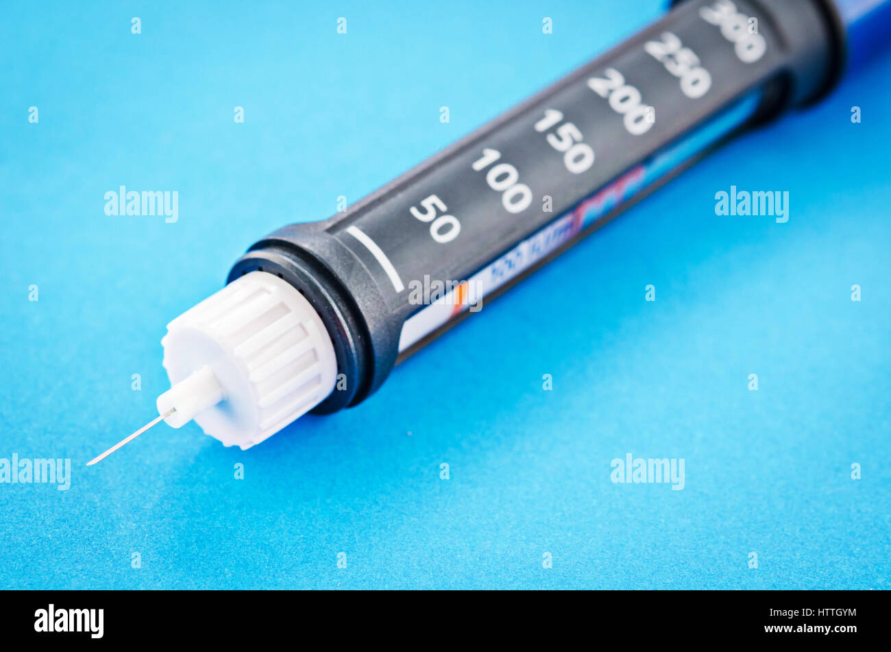 Stylo à insuline remplir sur fond bleu. Banque D'Images