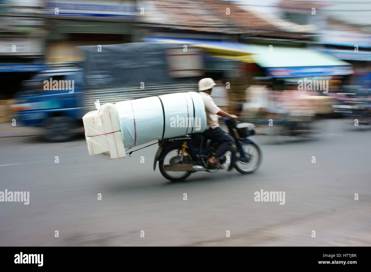 HO CHI MINH, VIET NAM- MAR 30 : Dangereux, risque de transport sur la rue vietnamienne, l'homme moto ride, transporter les marchandises en surcharge, volumineux, Banque D'Images