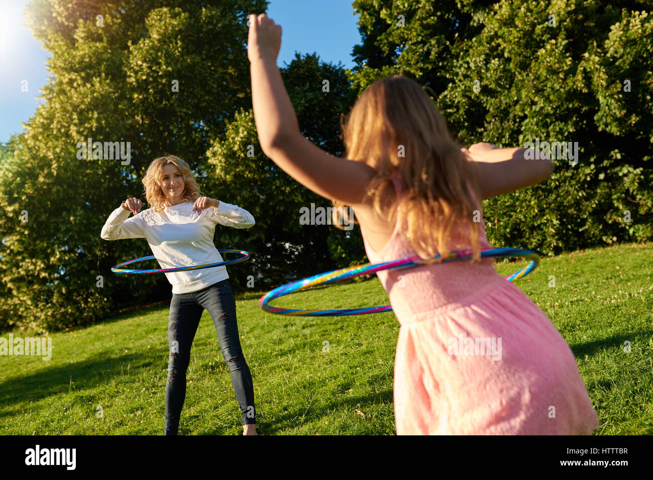 Et mère heureuse petite fille jouant avec cerceaux tout en profitant d