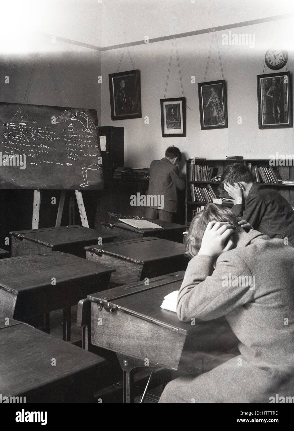 Années 1930, historiques, deux garçons de l'école au travail acharné de la révision à un bureau dans une salle de classe, en Angleterre. Banque D'Images