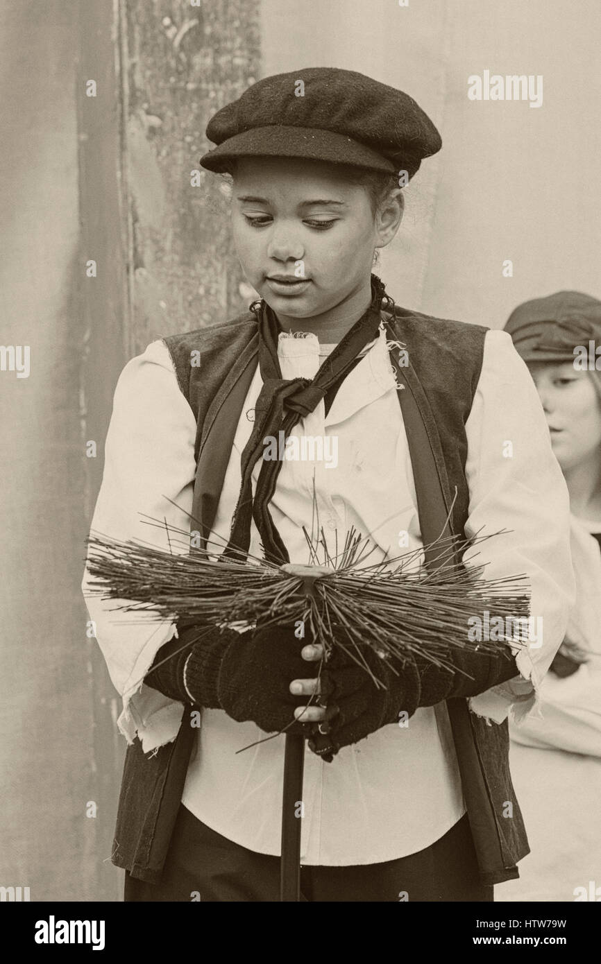 Chimneysweep enfant victorien, ramoneur, le chant au Festival victorien de Noël à Portsmouth, Hampshire, England UK en Novembre Banque D'Images