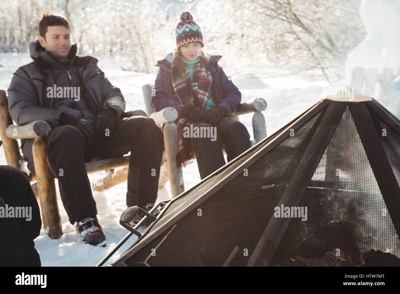 Couple skieur assis près du feu Banque D'Images