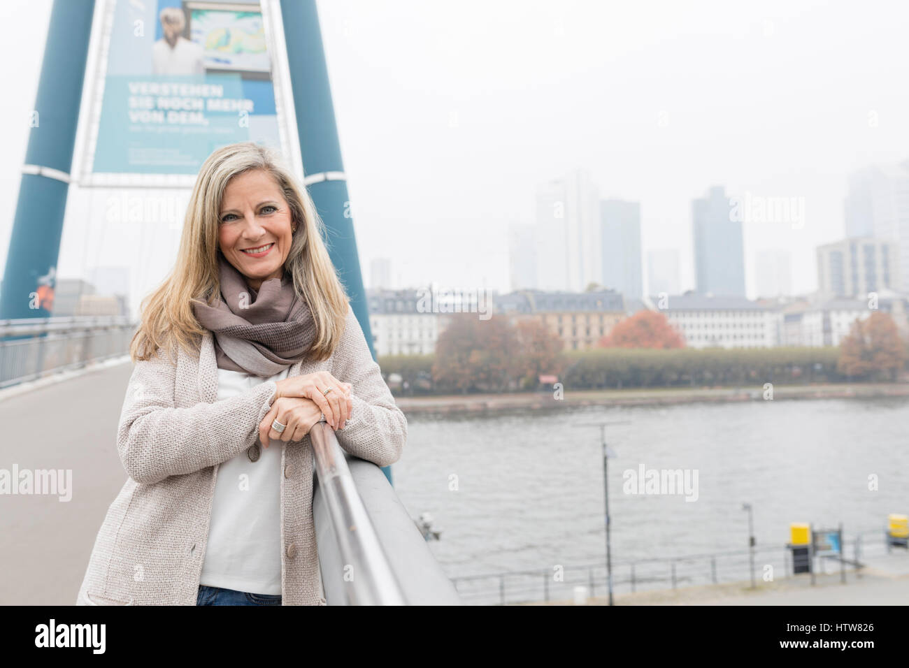 Middle-aged woman standing on a bridge Banque D'Images