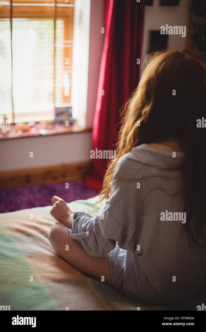 Woman sitting on bed at home Banque D'Images