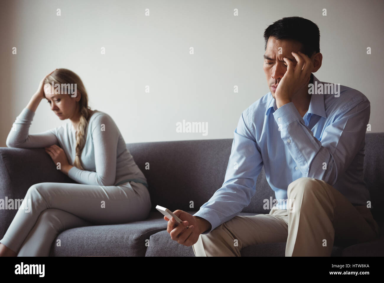 Couple assis sur un canapé et d'ignorant Banque D'Images