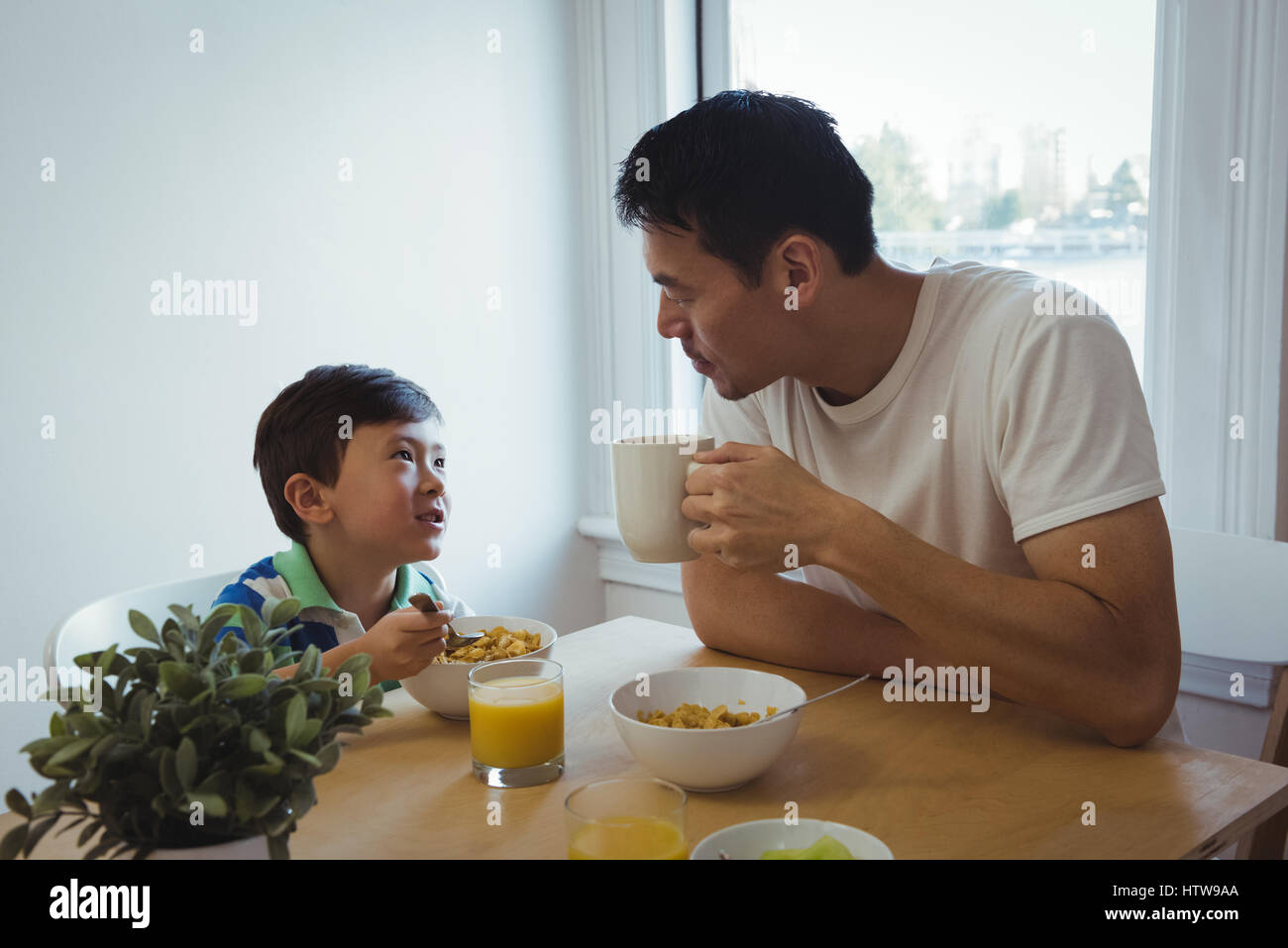 Père et fils interagir pendant le petit-déjeuner Banque D'Images