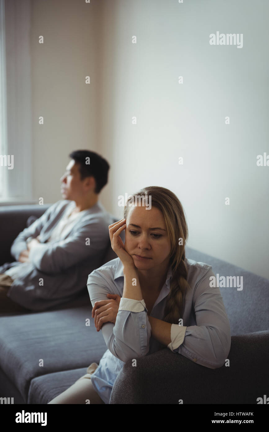 Couple assis sur un canapé et d'ignorant Banque D'Images