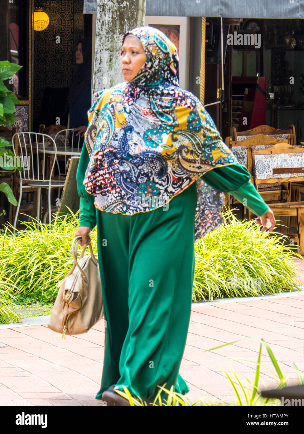 Un musulman singapourien woman walking in Bussorah zone piétonne. Banque D'Images