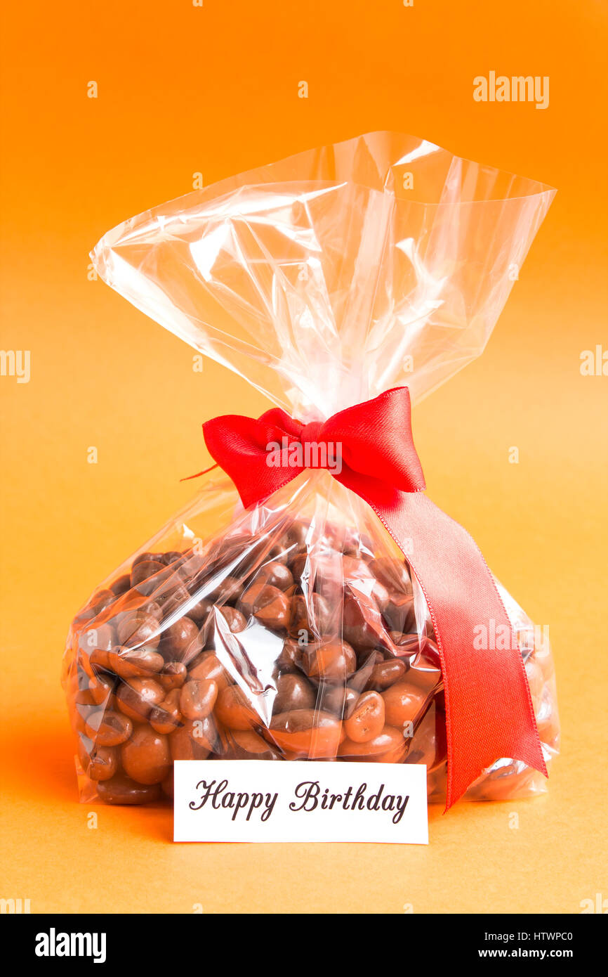 Cadeau d'anniversaire, Dragee chocolat avec des amandes et les canneberges dans du cellophane. Banque D'Images