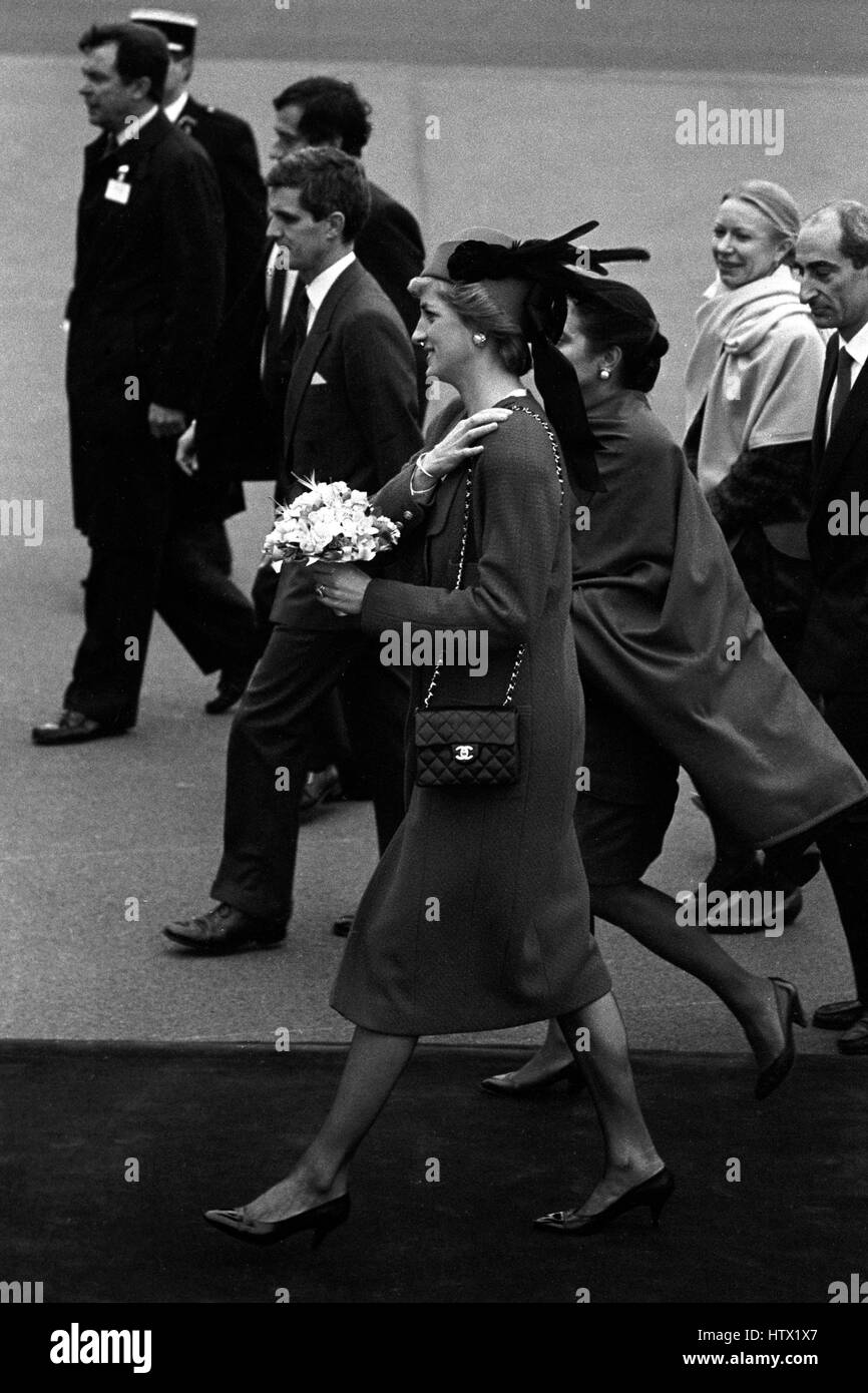 La princesse de Galles, vêtu d'un manteau en laine rouge Chanel avec des boutons d'or, surmonté d'un chapeau rouge garni de plumes, arrive à l'aéroport d'Orly, près de Paris, pour une visite officielle de cinq jours avec son mari le prince Charles. Banque D'Images
