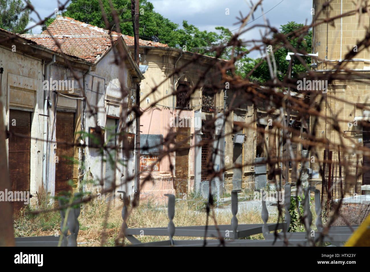 Des bâtiments abandonnés derrière des barbelés rouillés dans la zone tampon entre les parties grecque et turque de Chypre, Nicosie Banque D'Images