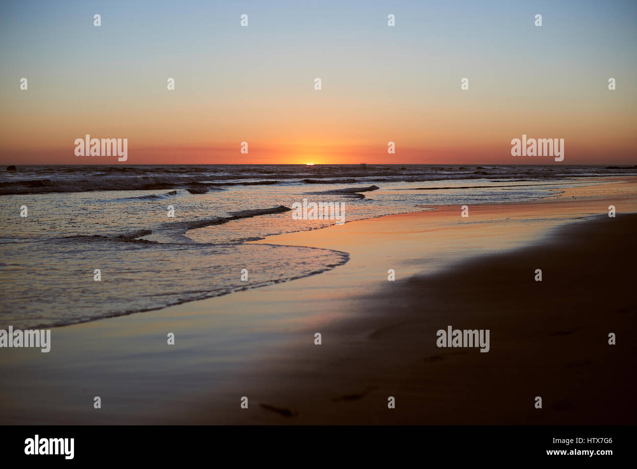 Paysage panoramique sur la plage coucher du soleil au crépuscule du temps. Bord de mer avec des reflets multicolores orange Banque D'Images