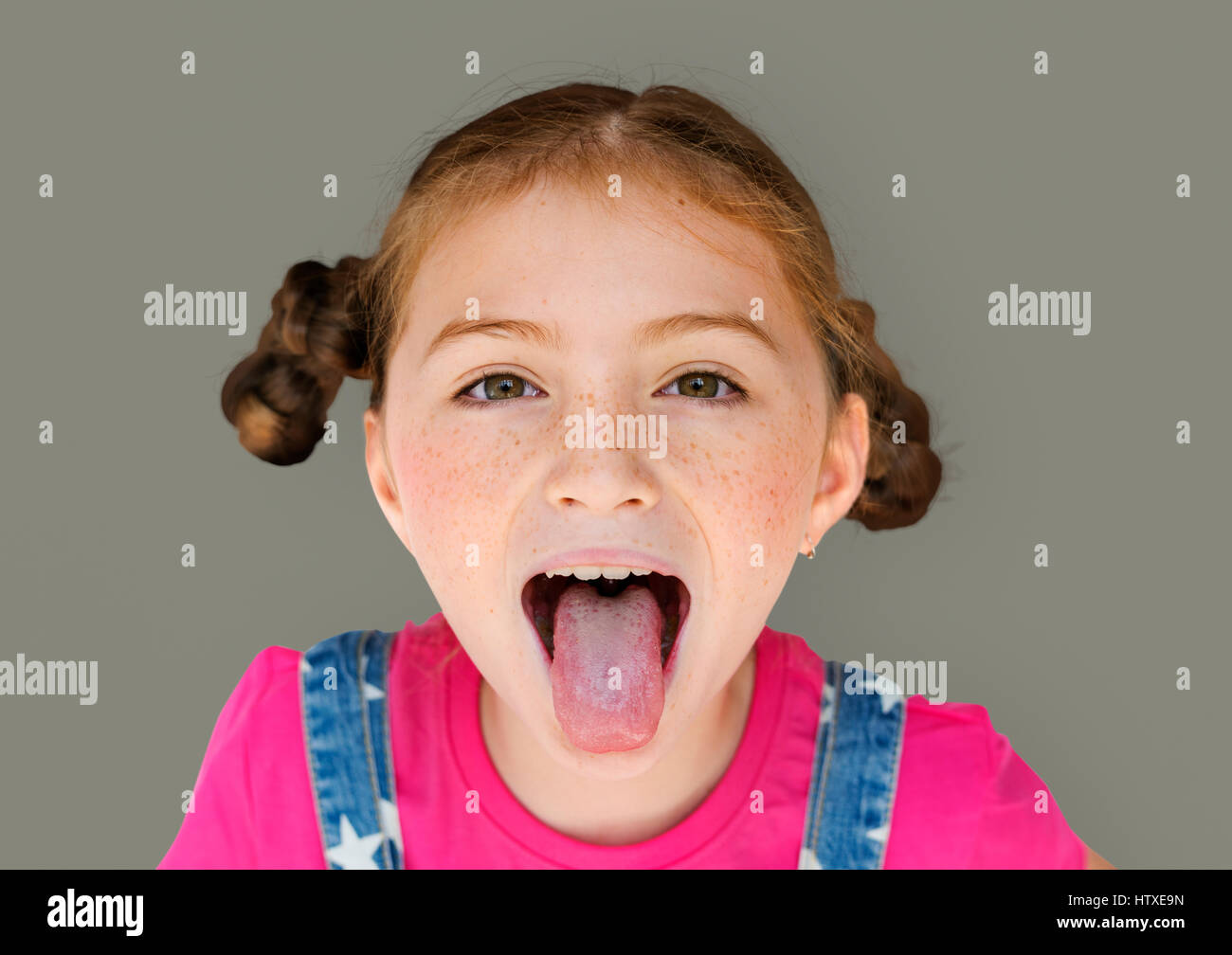 Little Girl Smiling Bonheur Sticking Out Tongue Studio Portrait Banque D'Images
