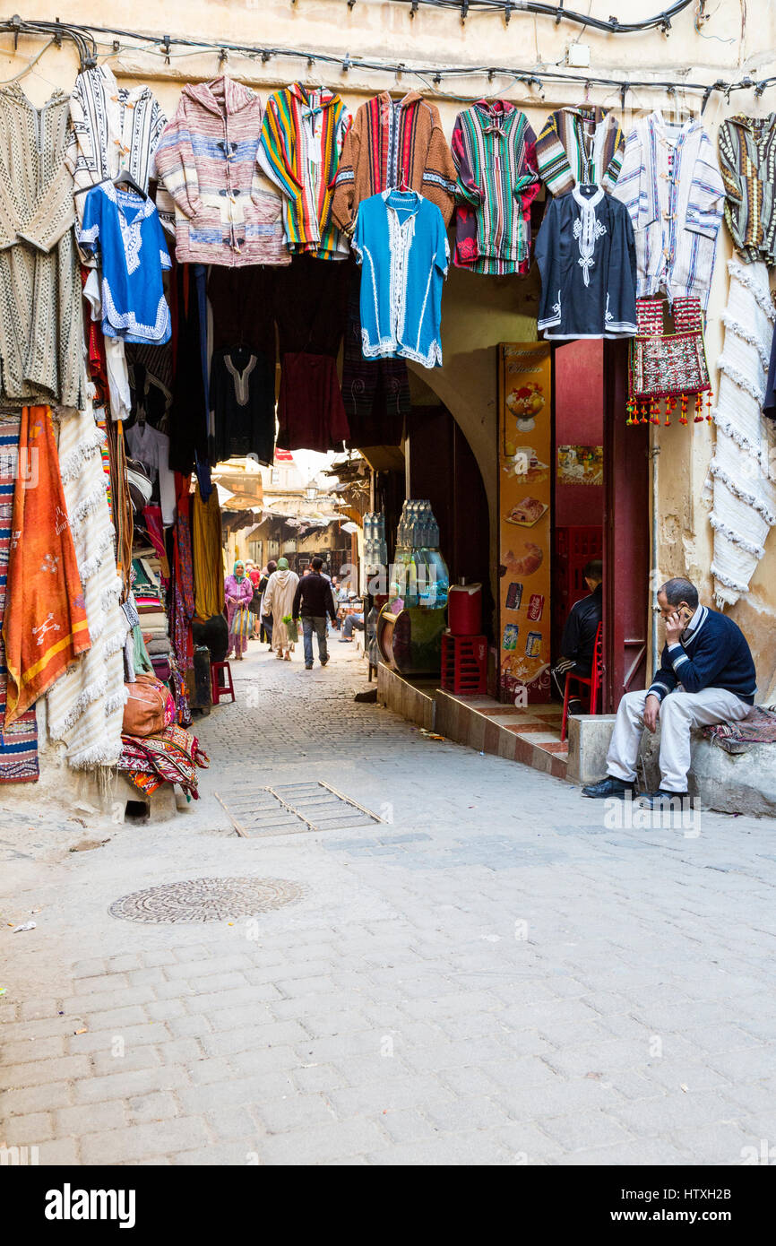 Fes, Maroc. Scène de rue à la médina. Vêtements à vendre. Banque D'Images