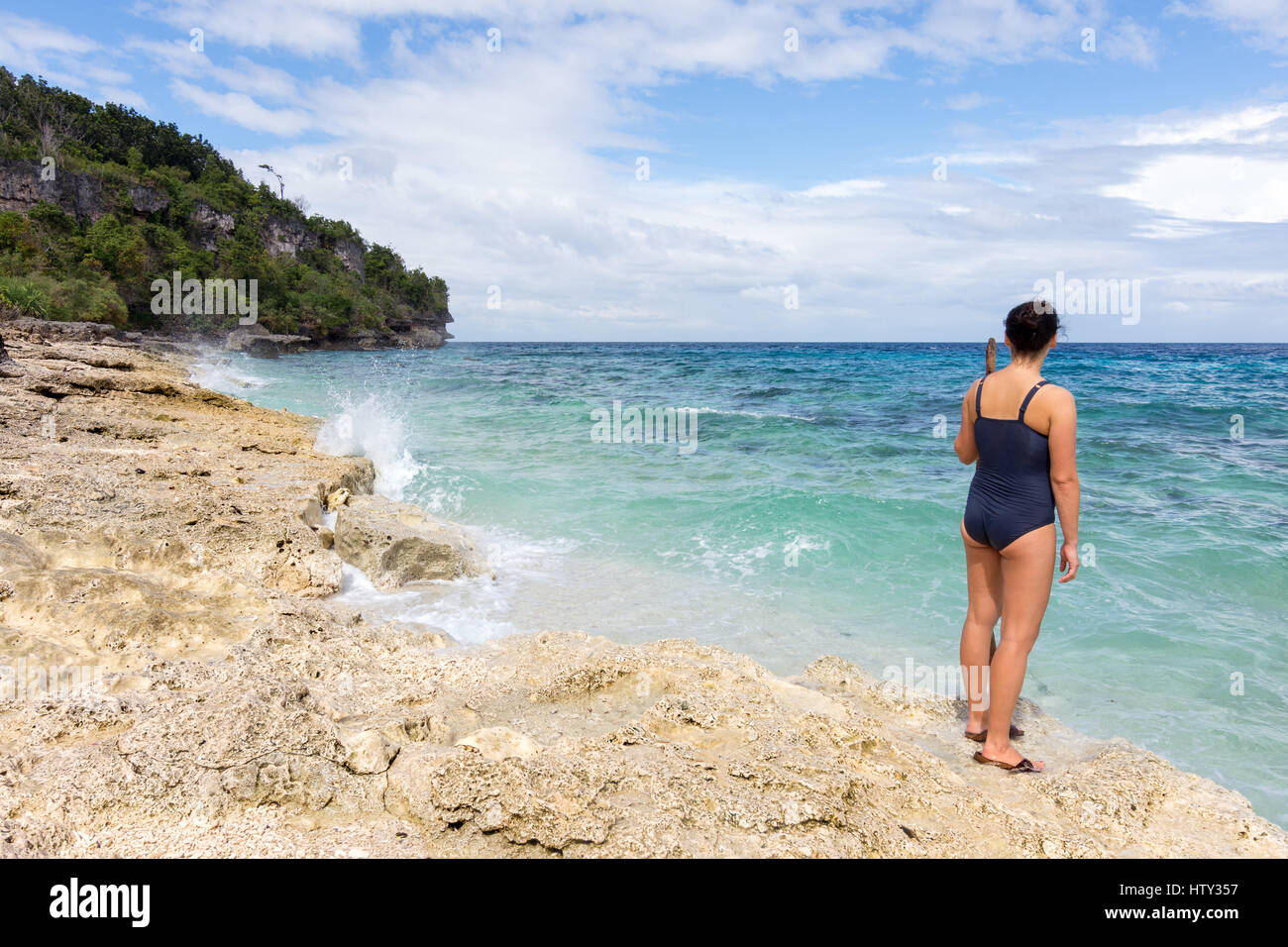 Jeune femme dans un maillot bleu veille sur un secret vide paradise Coral Beach. Banque D'Images