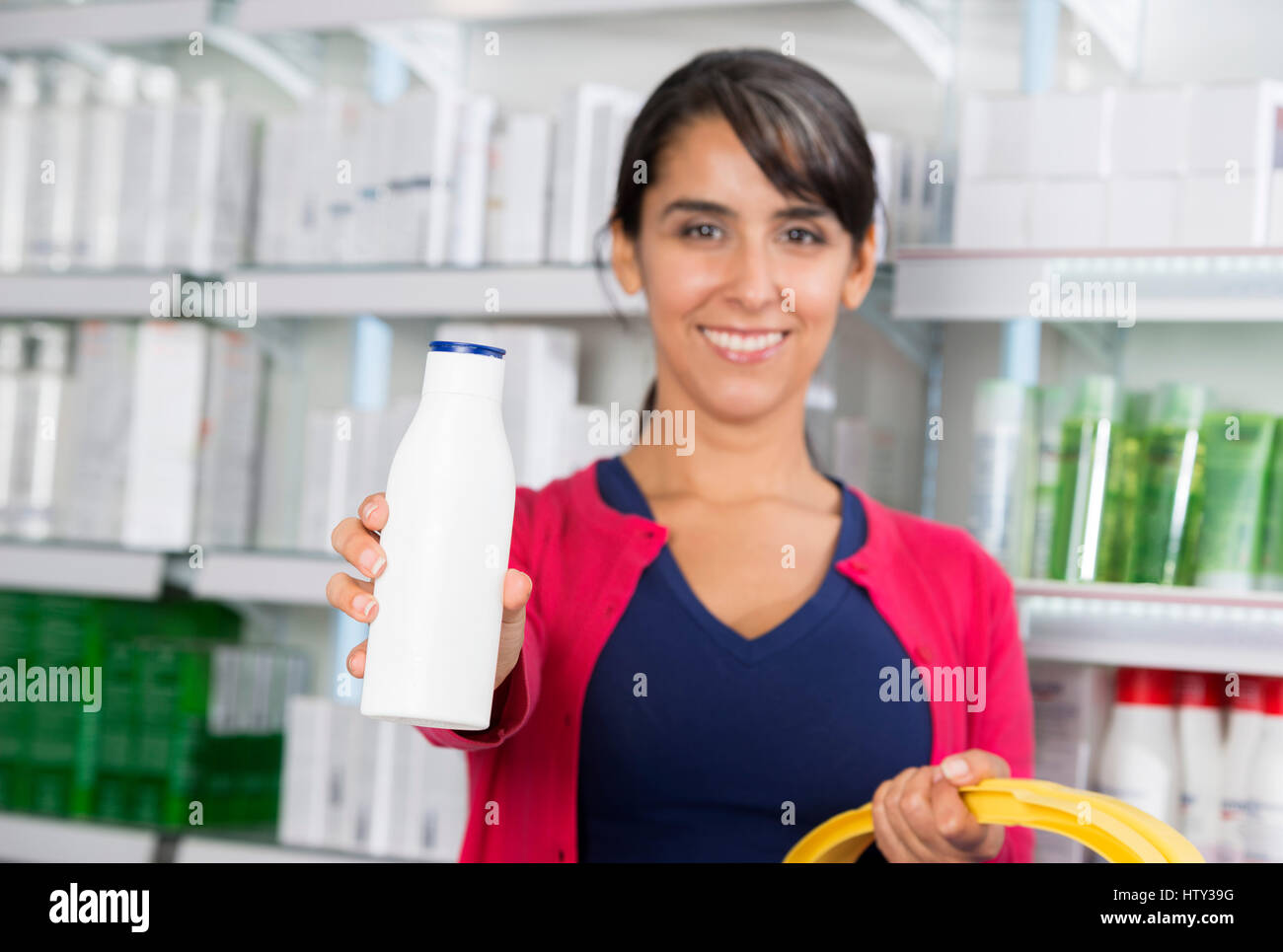 Femme recommandant de shampooing dans la pharmacie Banque D'Images