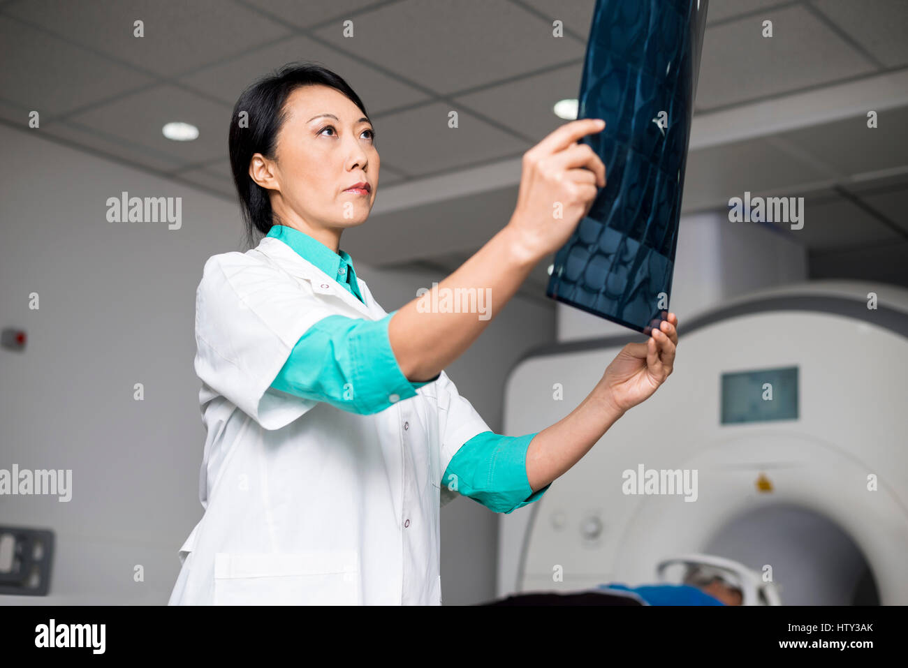 Doctor examining x-ray pendant que le patient couché sur la machine ct scan Banque D'Images