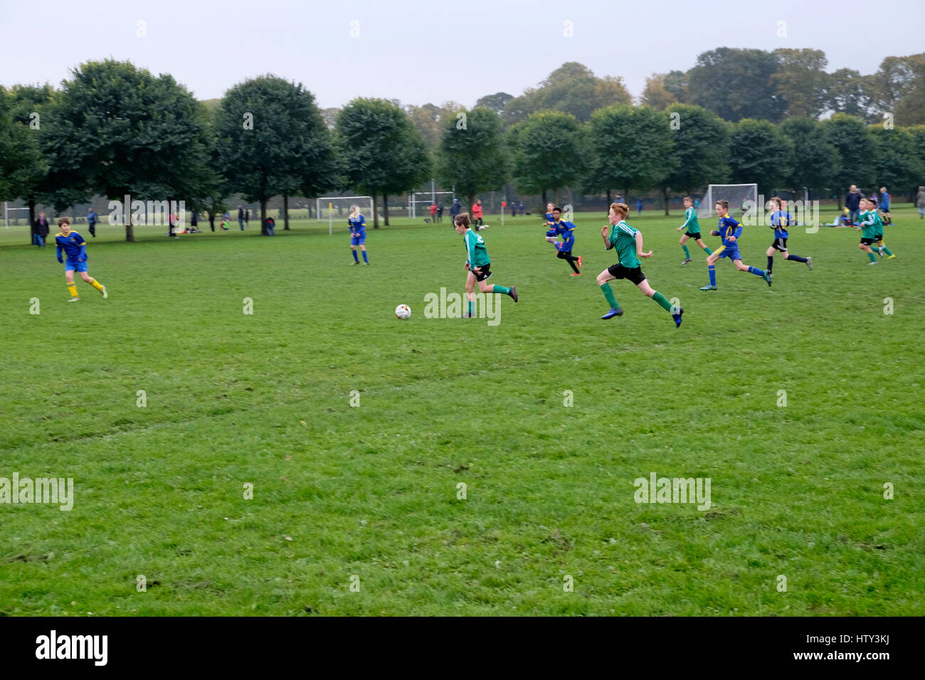 Garçons enfants en train de jouer équipe junior football ballon dans un parc samedi matin Royaume-Uni Grande-Bretagne KATHY DEWITT Banque D'Images