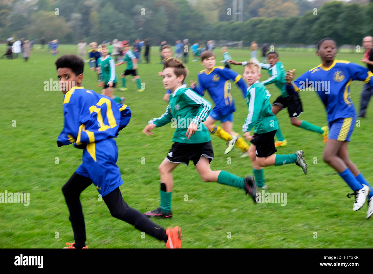 Des garçons qui jouent au football dans un parc le samedi matin R.-U. KATHY DEWITT Banque D'Images
