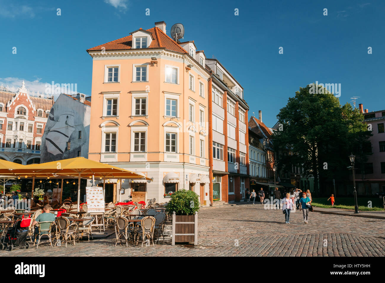 Riga, Lettonie - 1 juillet 2016 : Les gens se reposant dans Street Cafe Restaurant dans la vieille ville de façades de vieille architecture et bâtiments près de la Place du Dôme à Sun Banque D'Images